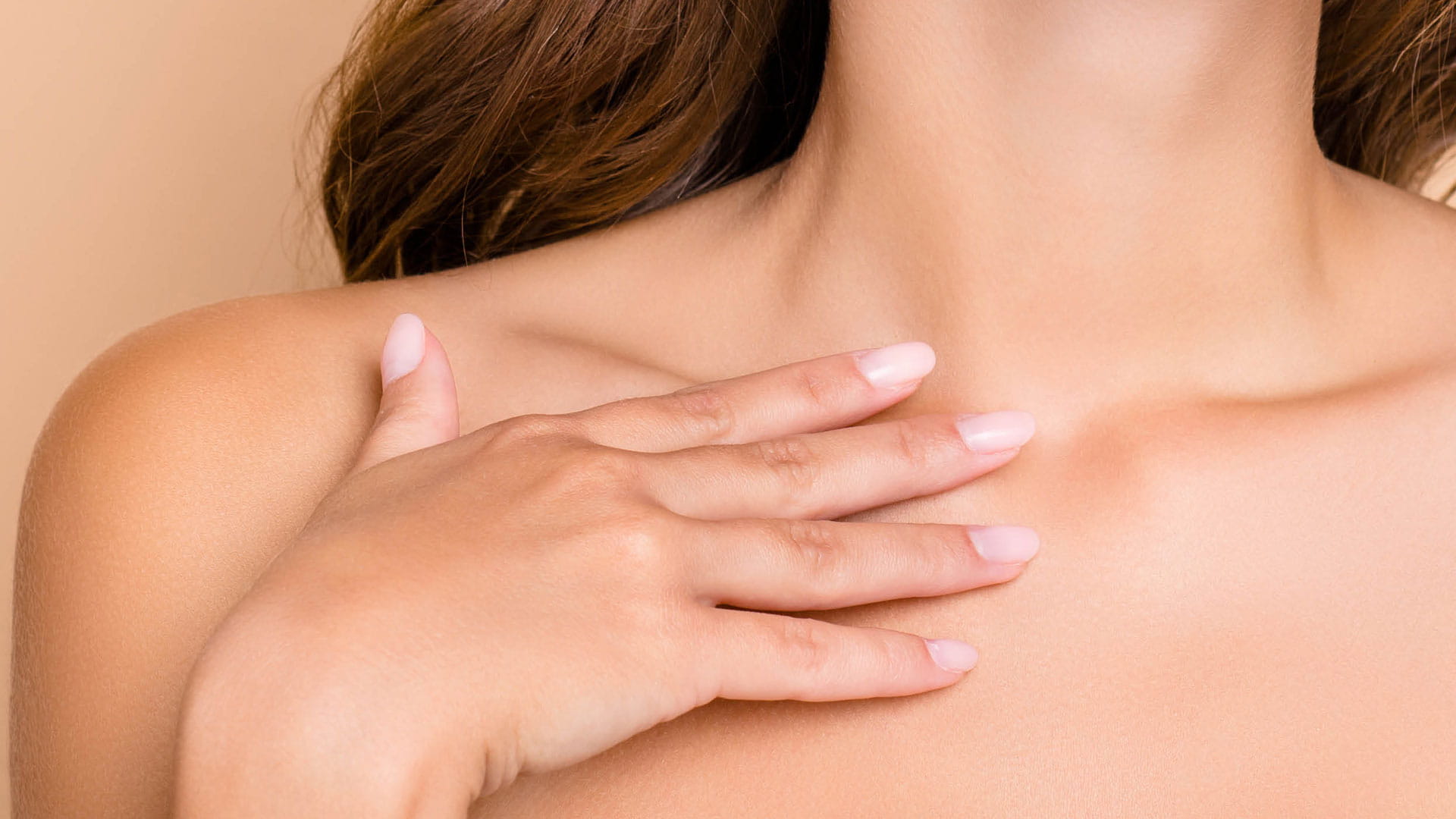 Header Hals- und Décolleté-Pflege Produktgruppe Körperpflege Eine Frau berührt mit Ihrer Hand ihr Décolleté