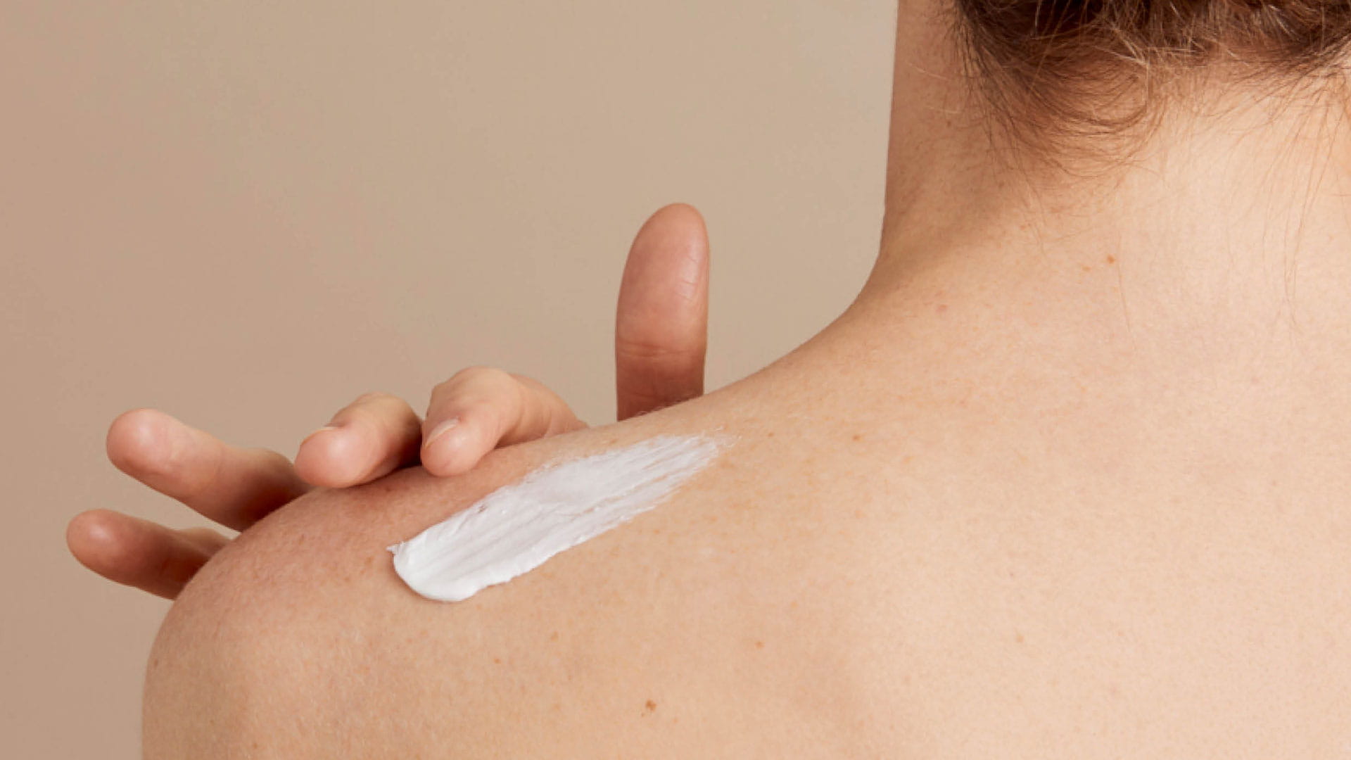 Header Bodylotion Körperöle Produktgruppe Körperpflege Eine Frau trägt sich Body Lotion auf der Schulter auf