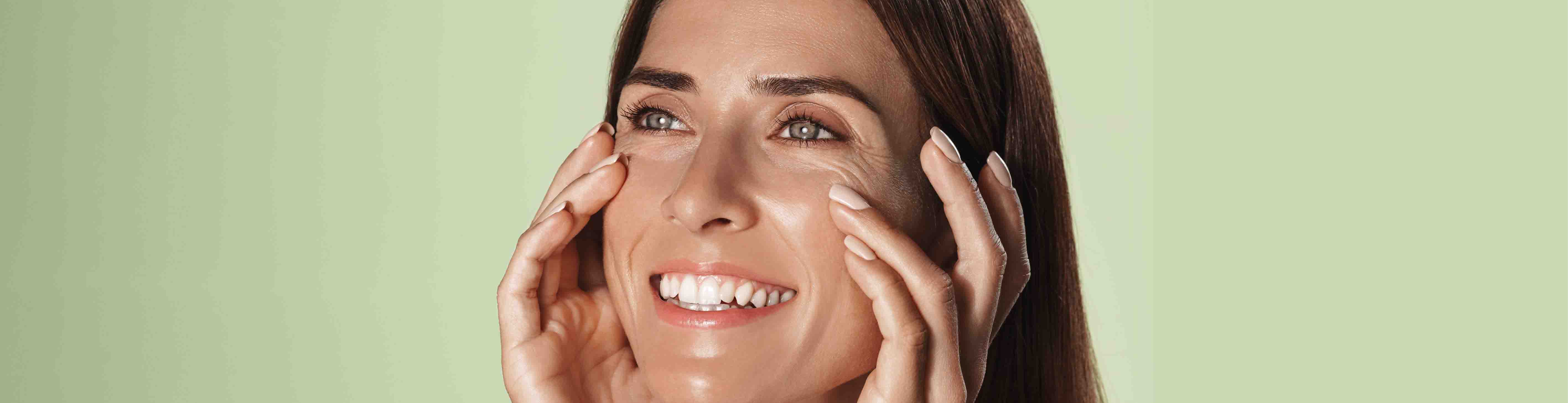 Zu früh bei Anti-Aging - kann jüngere Haut damit etwas anfangen? Junge Frau betastet Ihr Gesicht und strahlt dabei
